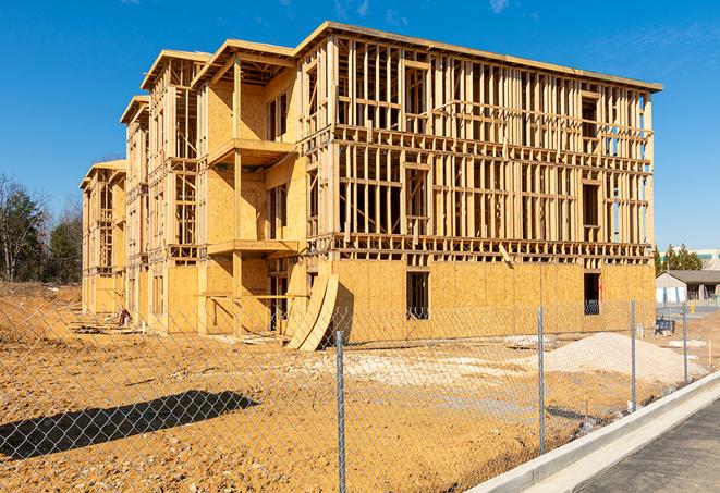 a construction site enclosed by temporary chain link fences, ensuring safety for workers and pedestrians in Elmer, NJ